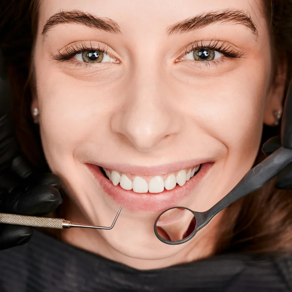 Patient smiling during dental examination with dentist tools