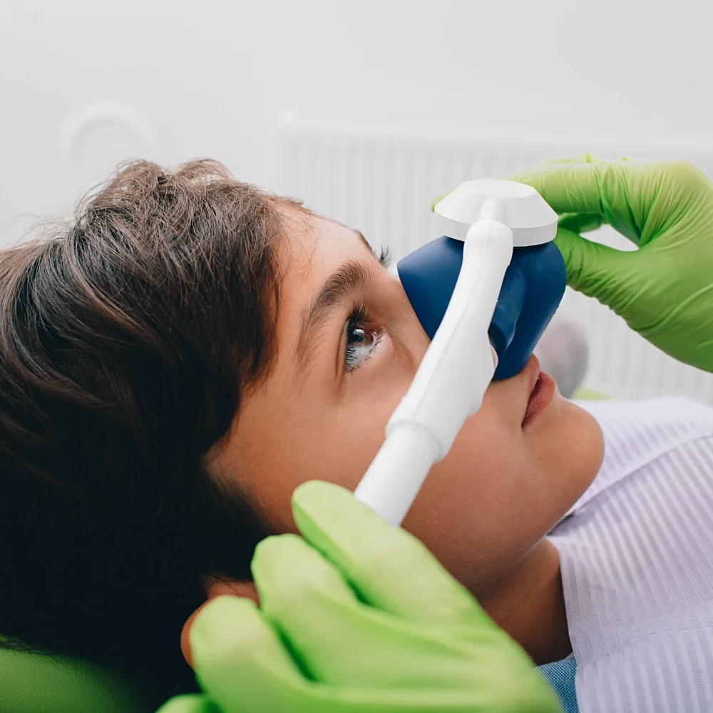Patient receiving nitrous oxide sedation dentistry treatment with a nose mask